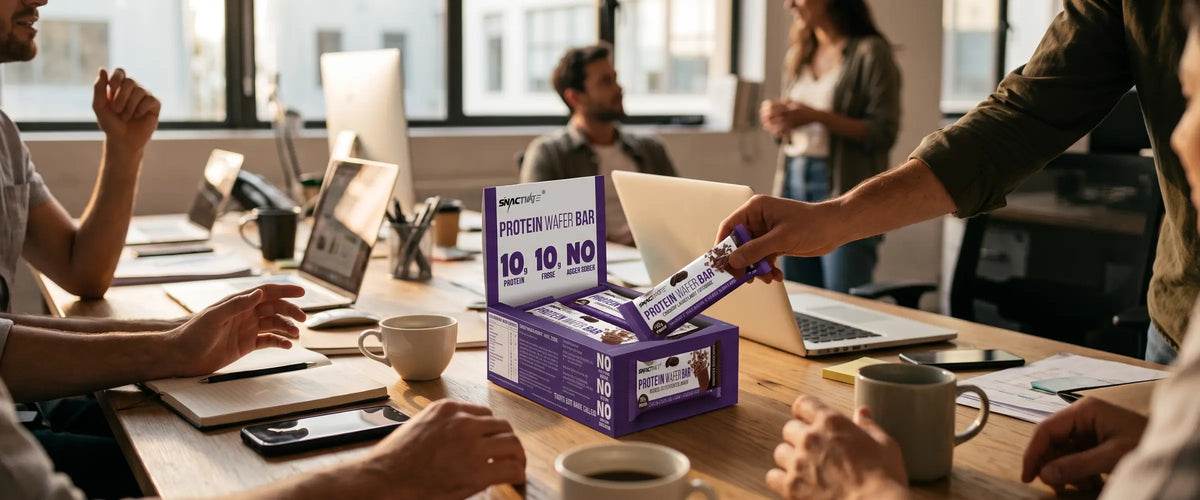 A Snactivate protein wafer bar handed out from an open box on an office desk